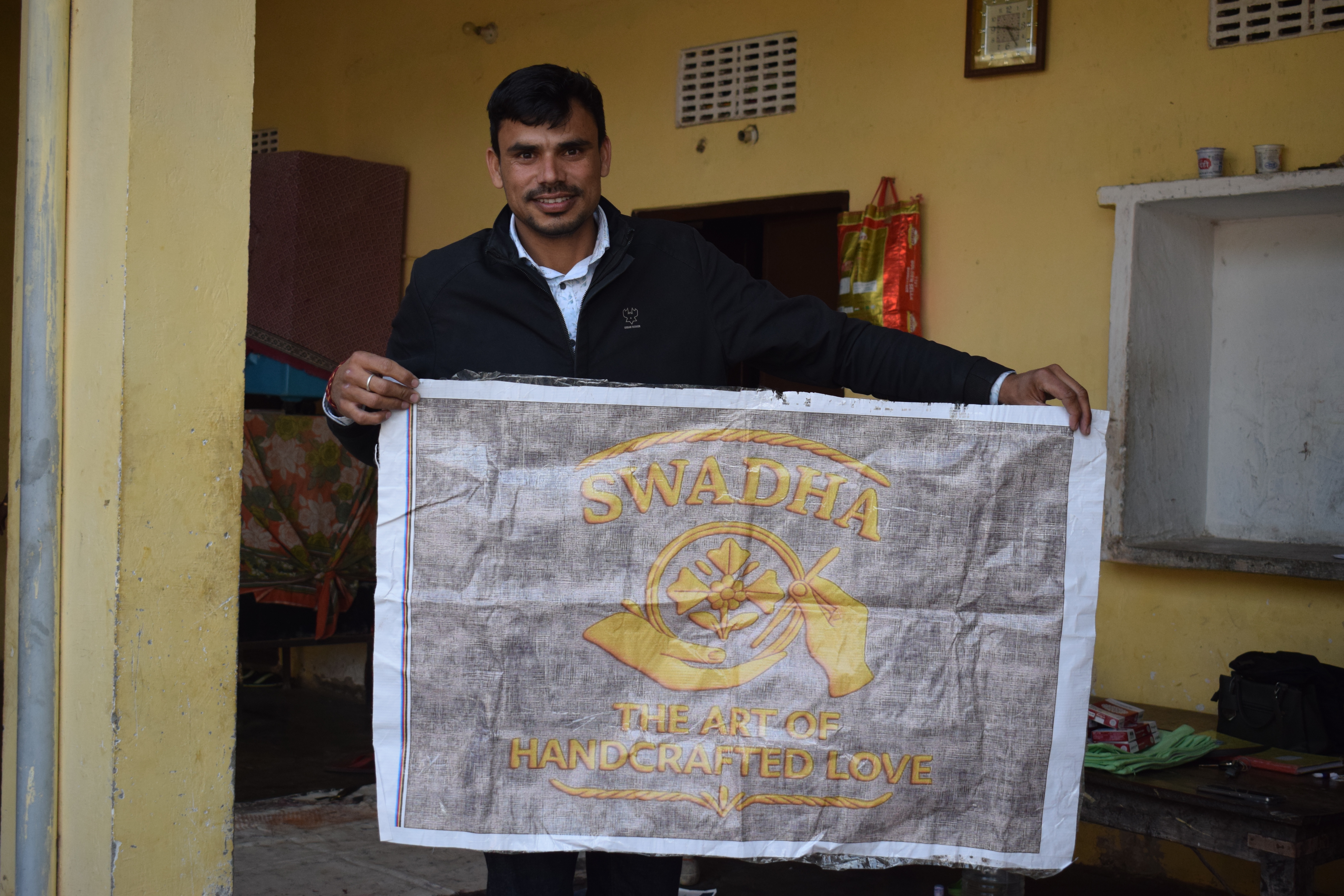 alt="Swadha team with women artisans working on handmade fabric"